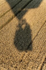 High angle shot of the shadow of a hot air balloon on a rural field