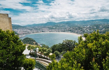 Fototapeta premium Aerial view of San Sebastian, Spain, surrounded by lush green hills and mountains