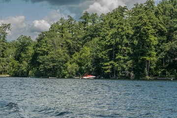 Vibrant red speedboat peacefully docked in the blue waters of Lake Winnipesaukee in New Hampshire