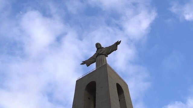 Low angle of Sanctuary of Christ the King Monument in Almada, Portugal under blue sky