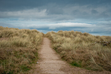 sandy and grassy entrance to the beach at Castlerock, Northern Ireland on a cloudy day. Picturesque...