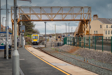 Diesel train is arriving towards the Castlerock Train station on a cloudy day. Stretch of track...