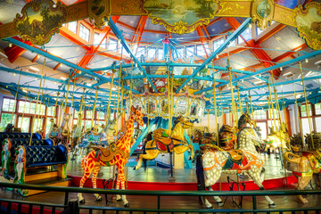 A view of a beautiful indoor carousel with bright colors.