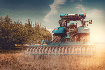 traktor von einem bauern auf der weide der farm beim mähen mit sonnenschein und schöner natur  - obrazy, fototapety, plakaty