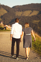 couple walking on a mountain trail with a nice view holding hands
