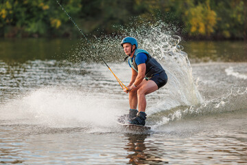 An athlete performs a trick on the water. Park at sunset. Wakeboard rider