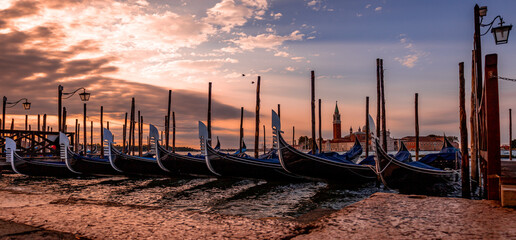 Stunning Sunset View of Gondolas Docked in Venice Italy - obrazy, fototapety, plakaty