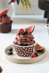 Chocolate muffins with cream, blueberries and figs.