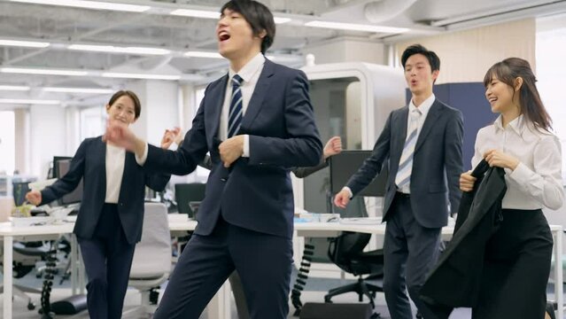 オフィスでダンスする会社員グループ