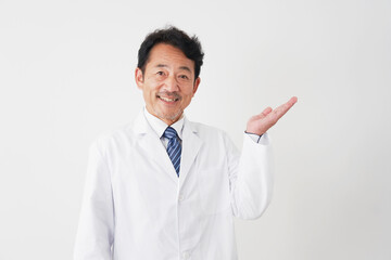 右側を手の平で指す中年の医師　白背景