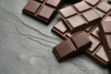 Delicious dark chocolate on black table, closeup. Space for text
