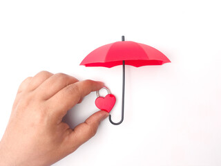 Hand holding red love padlock protect by red umbrella on a white background