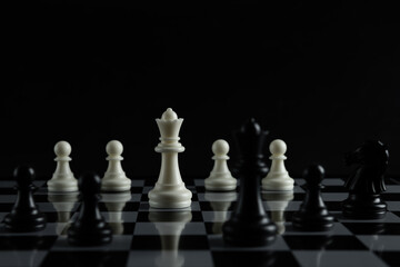 Pieces on chess board on black background for playing game and strategy.