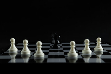 Pieces on chess board on black background for playing game and strategy.