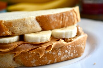 Peanut butter and banana sandwich on a white plate 