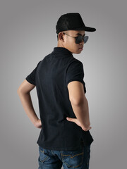 Rear view of Asian boy wearing black shirt hat and sunglasses, looking to the side