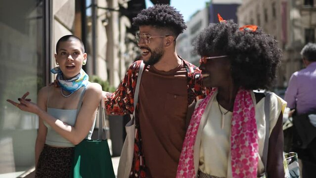 Young and diverse group of friends and tourists shopping and browsing stores in the city while on a vacation
