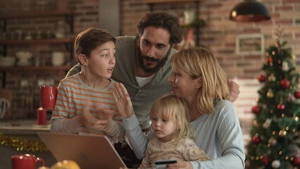 Happy young caucasian family online shopping for presents during Christmas and New Year Holidays - Powered by Adobe