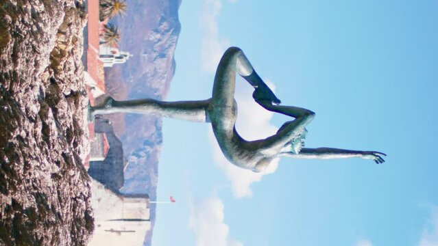 The statue Dancer , Ballerina in Budva, Montenegro, against the backdrop of the Old Town and mountains. Vertical video.