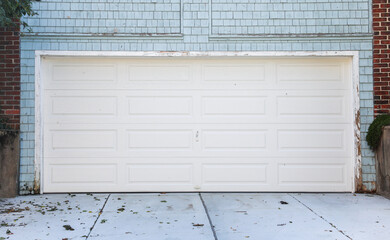suburban house with a white garage door, nestled in a green garden, epitomizing home, security, and...