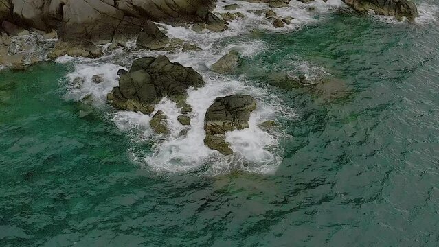 Aerial Tilt Down Perspective of Turquoise Waters and Coastal Rocks in Looc Bay, Philippines.