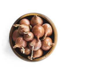 Red onions in wooden bolw  on white background.has path