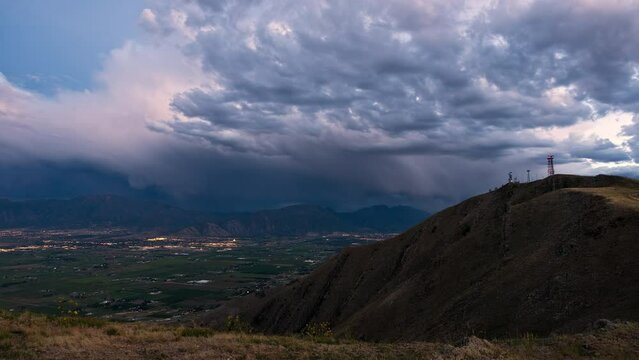 Timelapse of clouds moving over Utah Valley as city lights turn on from Payson Utah, looking from West Mountain.