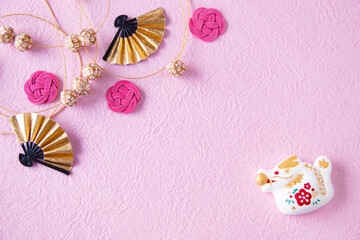 日本の正月イメージ　干支の辰とピンクの水引と手毬のガーランドと金の扇（ピンクバック）