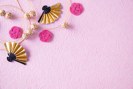日本の正月イメージ　ピンクの水引と手毬のガーランドと金の扇（ピンクバック）