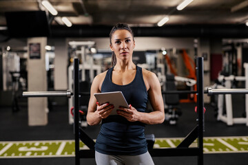 Fototapeta na wymiar Portrait of a female personal trainer holding tablet and looking at the camera.