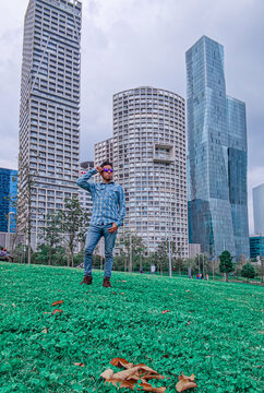 Hombre joven disfrutando en un parque de la ciudad con edificios al fondo