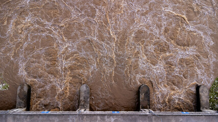 Aerial view of water released from the drainage channel of the concrete dam is a way of overflowing...