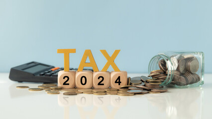 Tax  in 2024 Concept. Tax wooden letter and 2024 number on wooden block and glass coin jar with ...