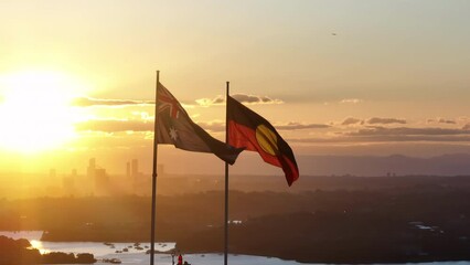 Australian and Aboriginal Flag Flying In the Sunset, Sydney in the Background, Golden Hour, Cinematic, Wide Angle Aerial, Circulating Shot
