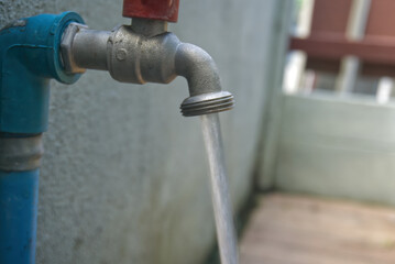 Metal tap with blue pipe turn on Let the water drain away blur background no people. concept for environment and shortage water in World for Water Day with copyspace