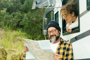 One happy traveler couple looking together a paper guide map to choose plan next travel...