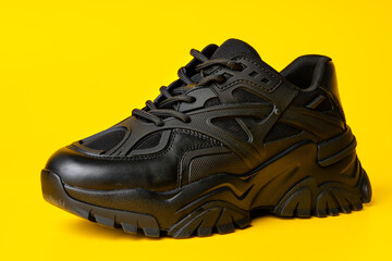 Black new sport sneakers on yellow background