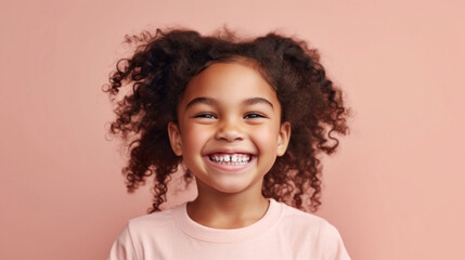 Little girl posing happily on a beige-pink backdrop.