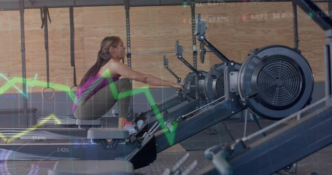 Animation of data on graph over biracial woman training on rowing machine at gym