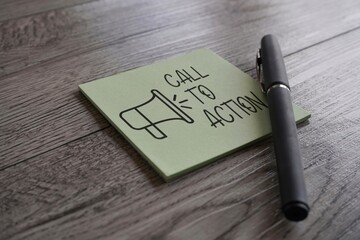 Closeup image of notepad with text CALL TO ACTION and pen on table. Business concept - obrazy, fototapety, plakaty