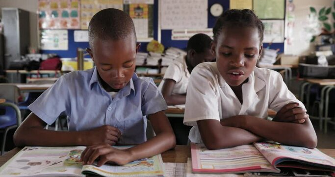 Close-up. Black African school children sitting at desk reading at a desk in a classroom in Africa