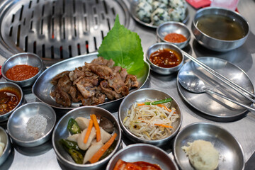 Korean barbecue set of ready for grill with slide beef, pork, soup and traditional Korean vegetables side dish as Kimchi on stainless stove at Korean bbq restaurant. Asian traditional food concept. - 650558621