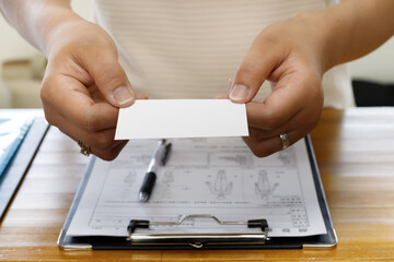 受付で診察券、カードを提示する女性の手元。