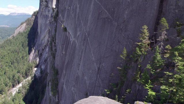 Aerial footage giant cliff rock formation, the Chief, Squamish, BC, beautiful Canadian outdoors, climbing wall, mountain. 4K 24FPS