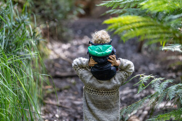 mother giving child a piggyback ride in the forest on an adventure