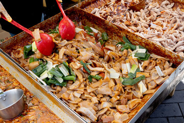 한국의 전통시장 거리에서 판매중인 돼지 껍데기 볶음 요리와 국자로...
