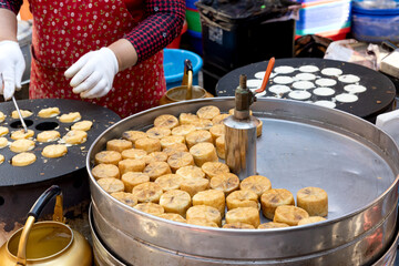 한국의 전통시장 거리에서 판매중인 국화빵과 굽고있는 상인의 손