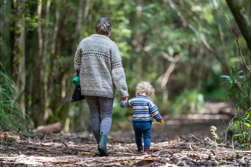 Poster Mother with baby in a carrier on her chest on a hike, taking a bush walk in Summer in a national park in Sydney, nsw, Australia © Phoebe