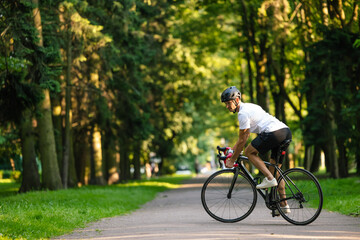Fototapeta premium Well-built young cyclist on a bike looking confident