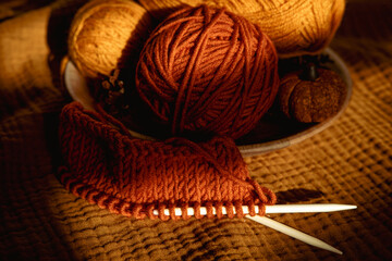 Earthy tones, warm colors yarn balls and knitting needles background. Cozy Crafts and Hobbies....